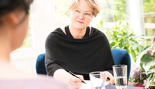 Dr. Astrid Gulba im Einzelcoaching, im Gespräch mit einer Klientin, während sie sich Notizen macht.