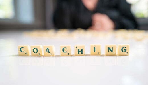 Scrabble-Steine, die das Wort ‚Coaching‘ bilden